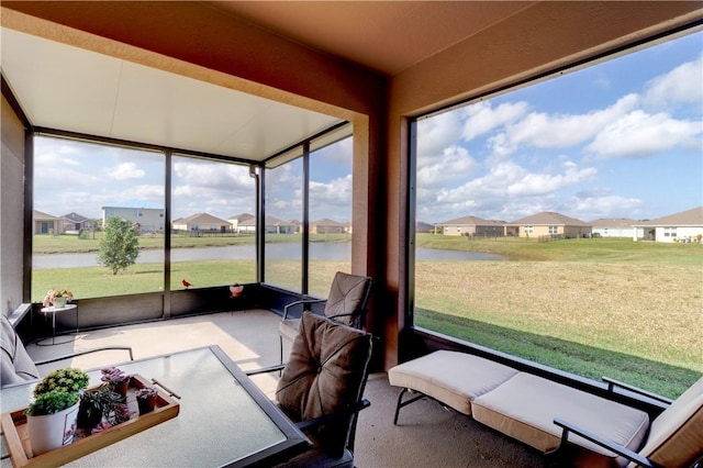 sunroom featuring a water view