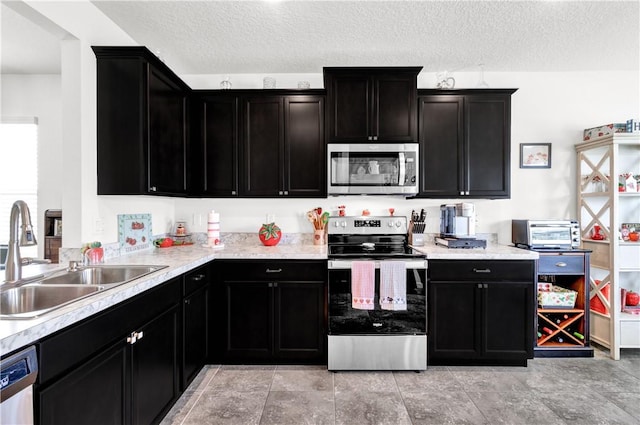 kitchen featuring appliances with stainless steel finishes, sink, and a textured ceiling