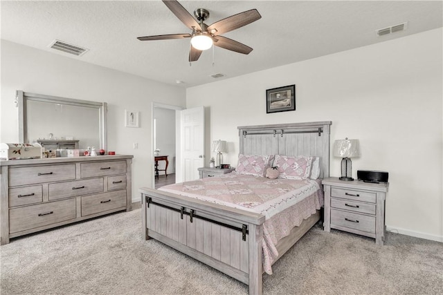 bedroom with light colored carpet, a textured ceiling, and ceiling fan