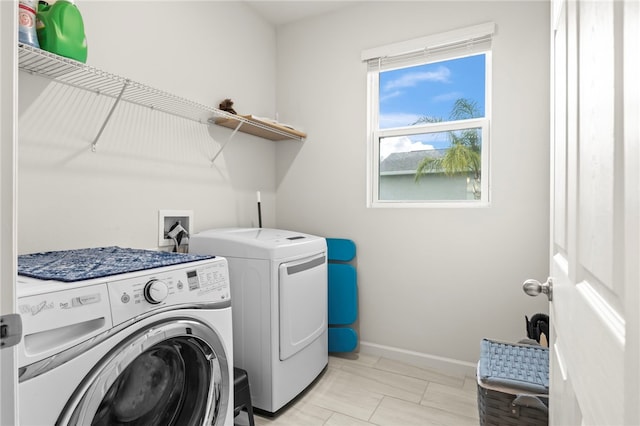 laundry room featuring laundry area, baseboards, and washer and clothes dryer