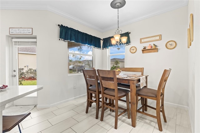 dining space featuring crown molding, baseboards, and a chandelier