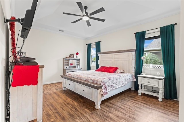 bedroom featuring visible vents, wood finished floors, crown molding, baseboards, and ceiling fan