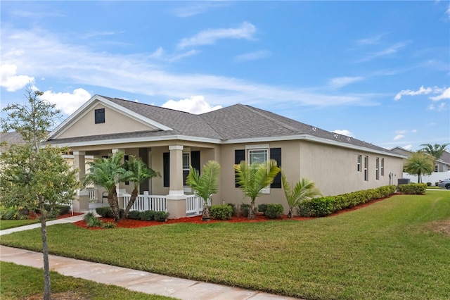 view of front of home featuring stucco siding, a porch, a shingled roof, and a front lawn