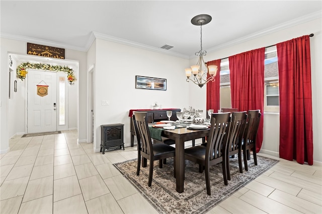 dining space with a notable chandelier, visible vents, baseboards, and ornamental molding