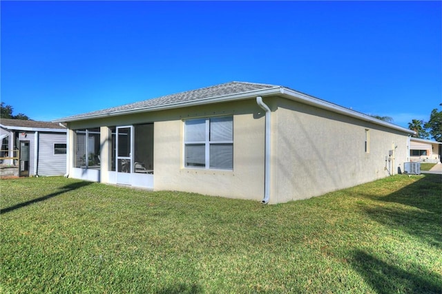 back of property with a lawn and central AC