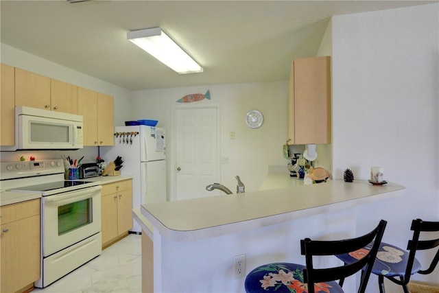 kitchen with kitchen peninsula, light brown cabinets, and white appliances