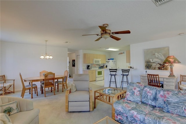 carpeted living room with ceiling fan with notable chandelier