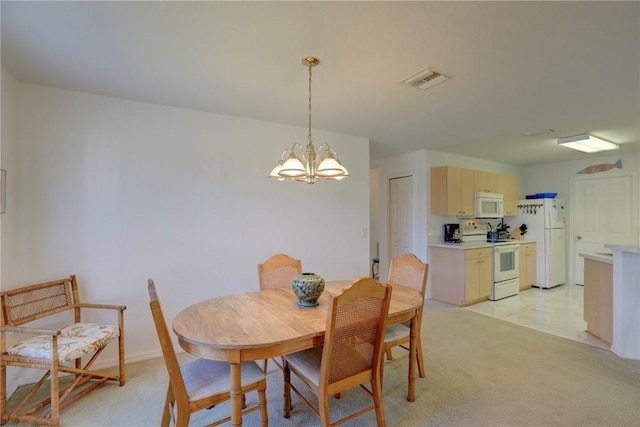 dining area with light colored carpet and an inviting chandelier