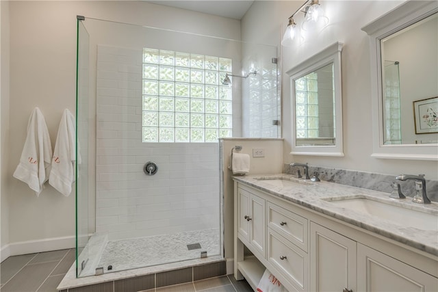 full bathroom featuring tile patterned flooring, a sink, a tile shower, and double vanity