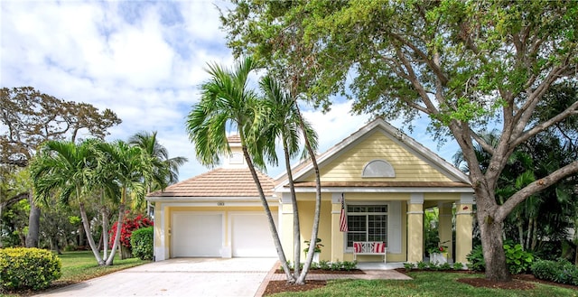 view of front of house with concrete driveway, a tiled roof, an attached garage, and stucco siding