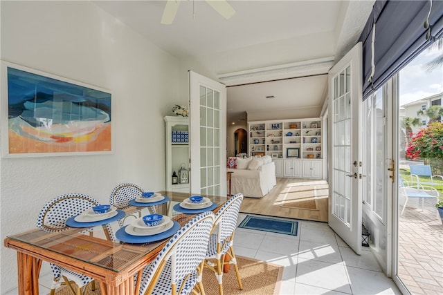 sunroom / solarium featuring a ceiling fan, a wealth of natural light, and french doors