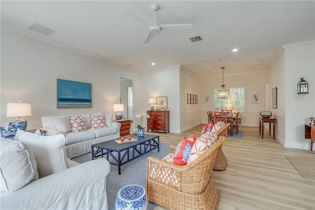 living room with light wood-type flooring, crown molding, baseboards, and recessed lighting