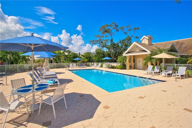 pool with a patio area and fence