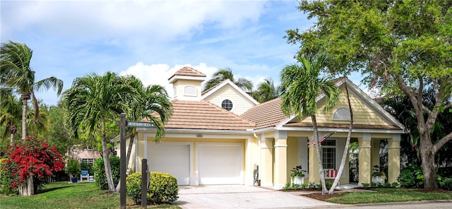 view of front facade featuring a garage, driveway, a porch, and stucco siding