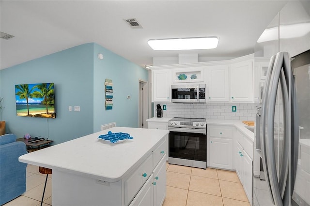 5367 Montego Cir, Hutchinson Island, FL 34949 - kitchen featuring stainless steel appliances, light tile patterned floors, light countertops, a kitchen breakfast bar, and decorative backsplash