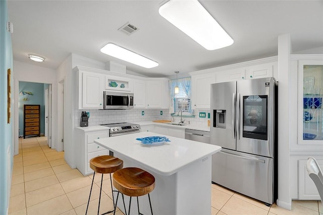 5367 Montego Cir, Hutchinson Island, FL 34949 - kitchen featuring stainless steel appliances, light tile patterned floors, a sink, and white cabinetry