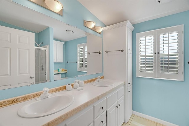 5367 Montego Cir, Hutchinson Island, FL 34949 - bathroom with a shower stall, double vanity, vaulted ceiling, baseboards, and tile patterned flooring