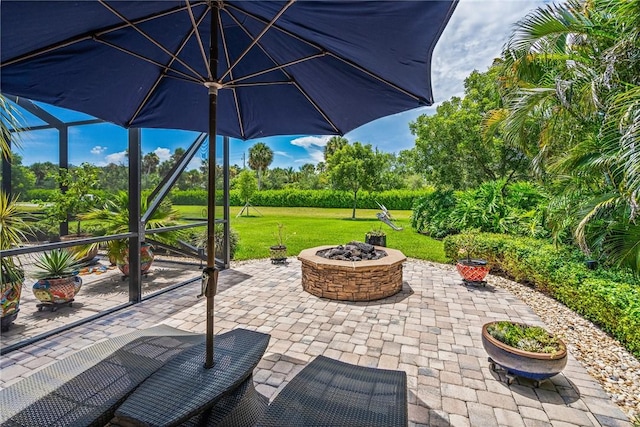 view of patio / terrace featuring a lanai and an outdoor fire pit