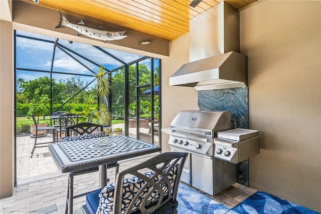 view of patio with glass enclosure and area for grilling