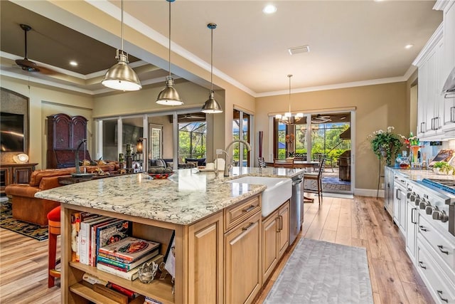 kitchen featuring white cabinets, a kitchen island with sink, a wealth of natural light, and light hardwood / wood-style flooring