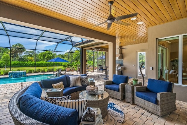 view of patio / terrace featuring an outdoor living space, ceiling fan, and glass enclosure