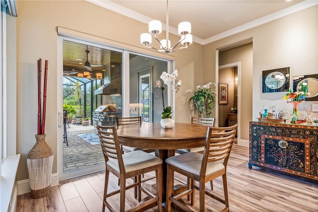 dining space with light wood-type flooring, an inviting chandelier, and crown molding