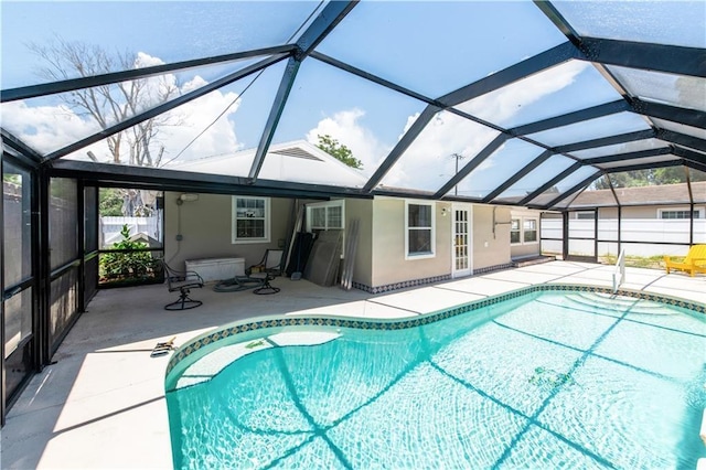 view of swimming pool with glass enclosure, a patio area, and a wall mounted AC