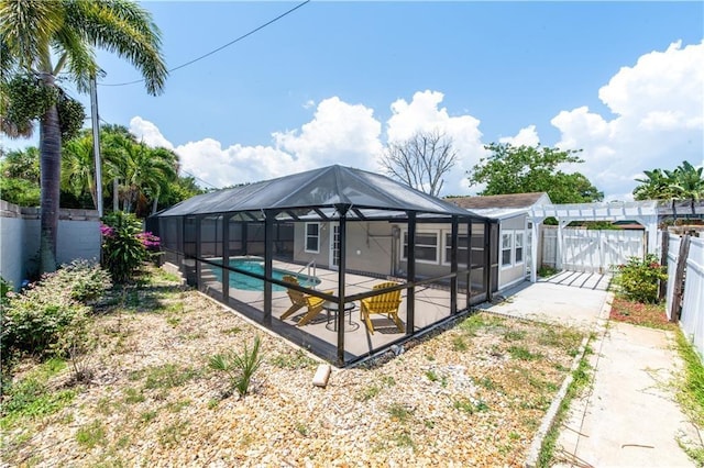 back of house with a lanai, a patio, and a fenced in pool