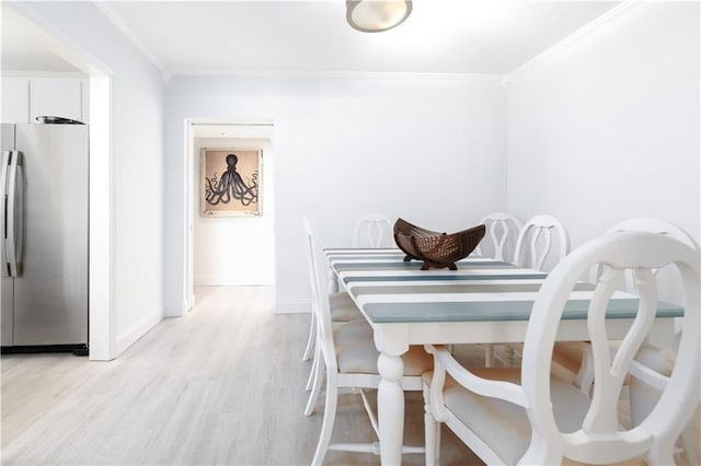 dining room with light hardwood / wood-style flooring and ornamental molding