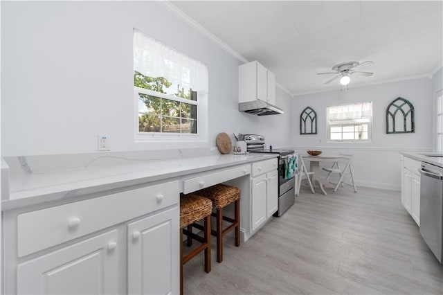 kitchen with white cabinetry, ceiling fan, light stone countertops, appliances with stainless steel finishes, and ornamental molding