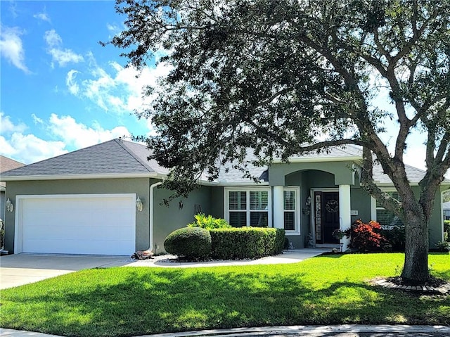 ranch-style house featuring a garage and a front lawn