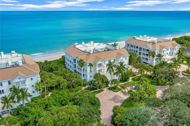 birds eye view of property with a water view and a beach view