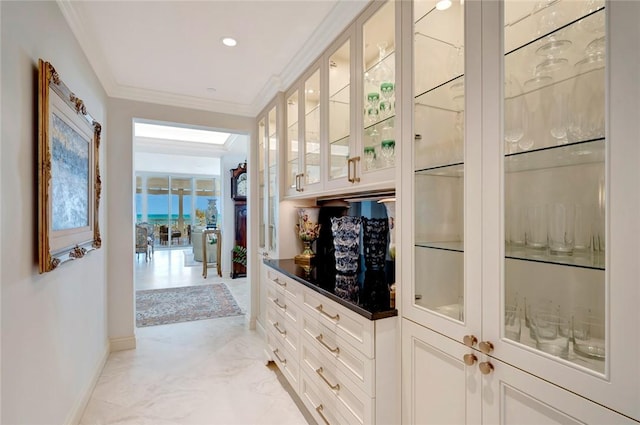 bar featuring white cabinetry and ornamental molding