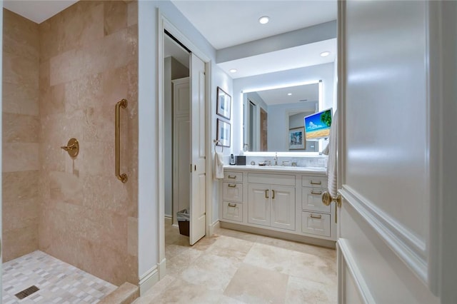 bathroom featuring tiled shower and vanity