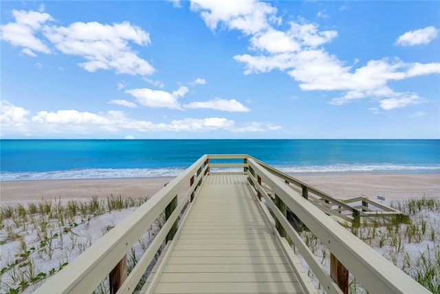 view of home's community with a water view and a beach view