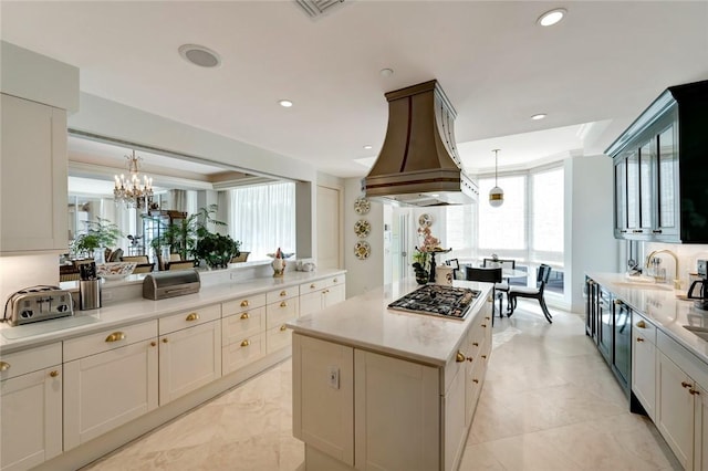 kitchen featuring custom range hood, a center island, hanging light fixtures, and stainless steel gas stovetop