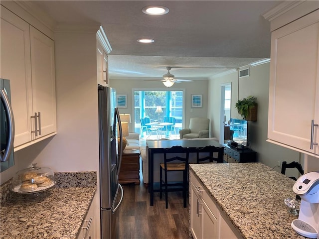 kitchen with white cabinetry, light stone counters, ornamental molding, and stainless steel refrigerator with ice dispenser