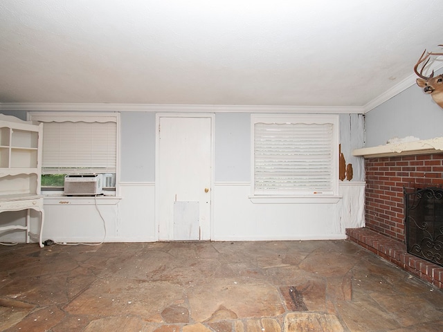 unfurnished living room with cooling unit, crown molding, and a fireplace