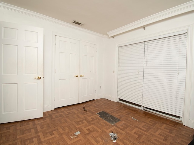 unfurnished bedroom with dark parquet floors, a closet, and crown molding