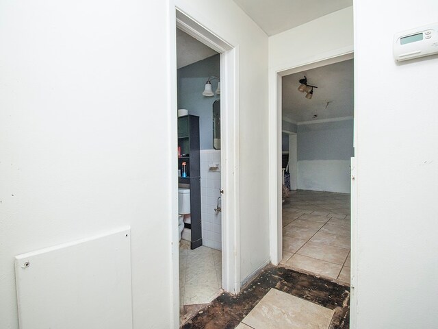 corridor with tile walls and dark tile patterned flooring