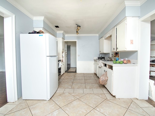 kitchen featuring ornamental molding, white refrigerator, light tile patterned floors, sink, and white cabinets