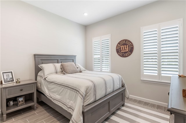 bedroom with light wood-type flooring and multiple windows