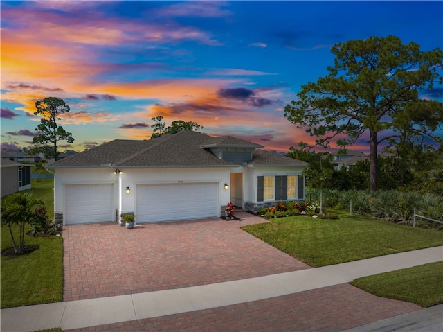 view of front of house featuring a garage and a lawn