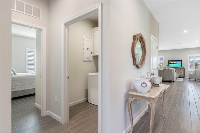 corridor with electric panel, light hardwood / wood-style flooring, and washer / dryer