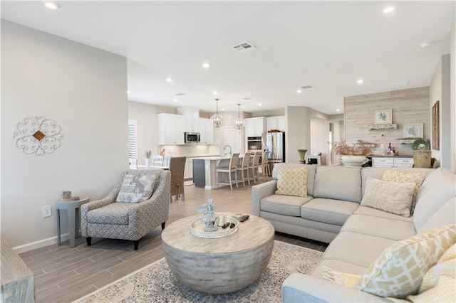 living room featuring light hardwood / wood-style flooring and an inviting chandelier