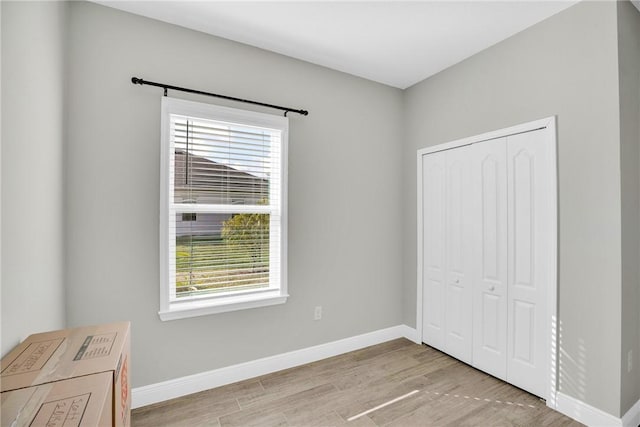 unfurnished bedroom with a closet and light wood-type flooring