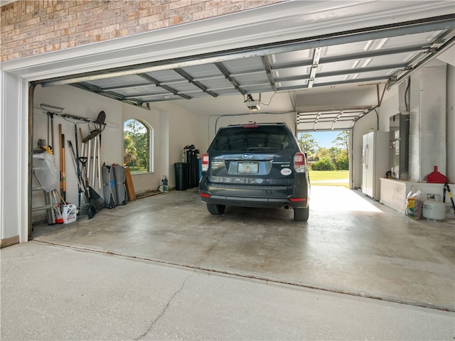 garage with white fridge and a garage door opener