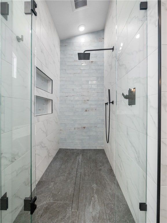 bathroom featuring walk in shower and vaulted ceiling