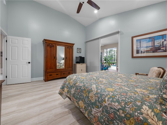 bedroom with light wood-type flooring, ceiling fan, vaulted ceiling, and a closet