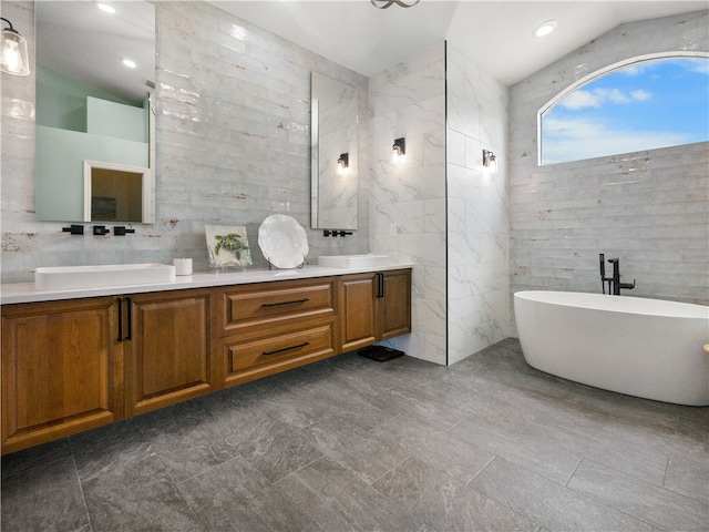 bathroom featuring tile walls, a bathing tub, and vaulted ceiling